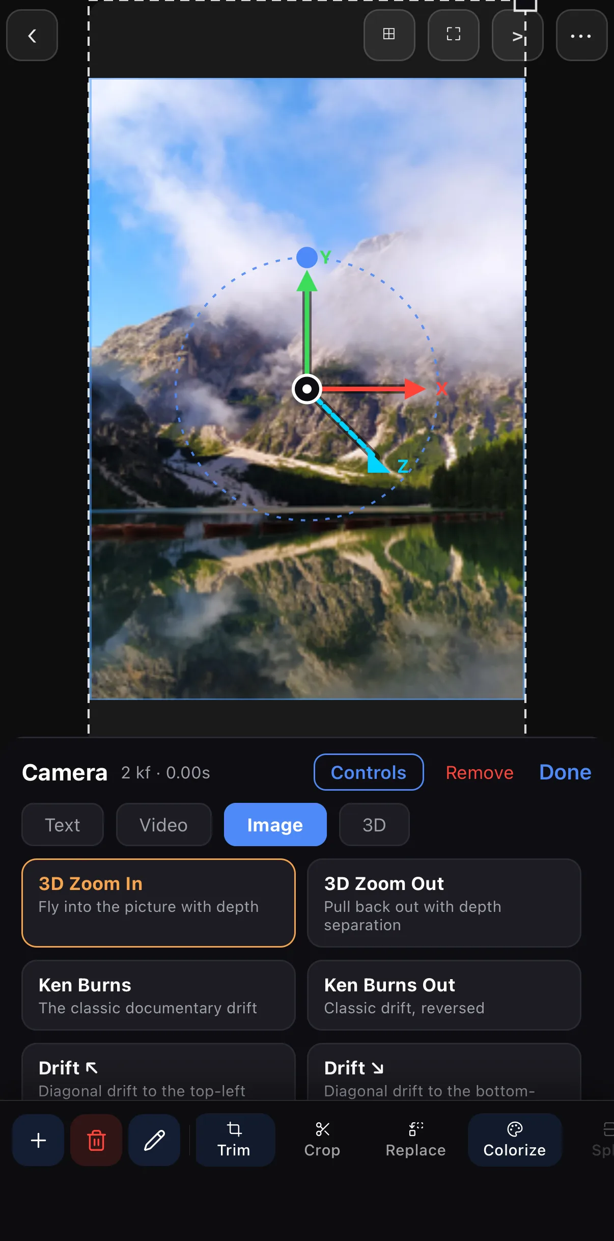 3D Zoom In applied: the camera gizmo — a green Y arrow, red X arrow, cyan Z arrow and a dotted orbit circle — sits over the mountain lake; the panel header reads Camera · 2 kf · 0.00s with the 3D Zoom In card highlighted.