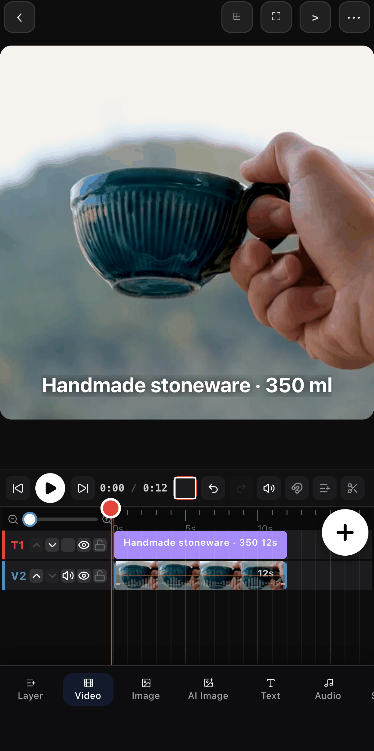 The square canvas with the mug and a white caption reading Handmade stoneware · 350 ml near the bottom; the timeline shows a T1 text row above the V2 video row.